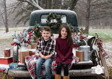 two kids sitting on a truck