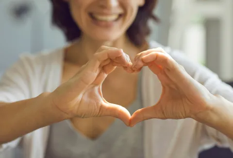 women holding up heart hands
