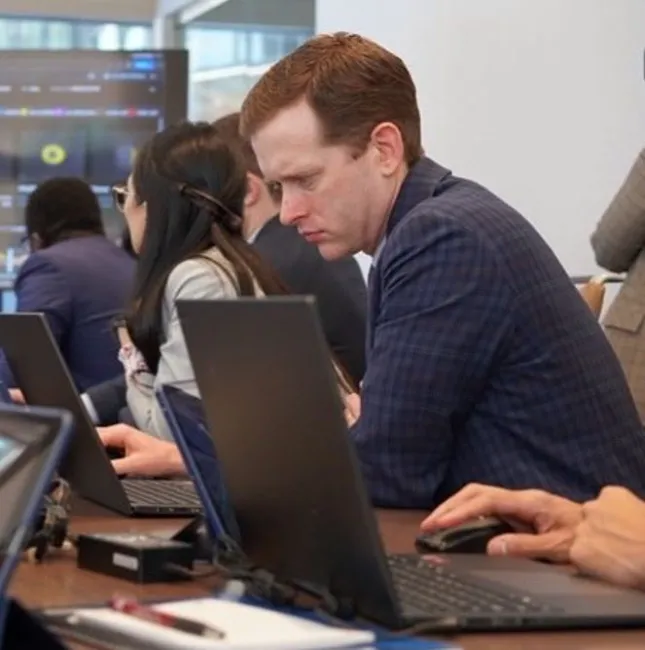 An attendee working on a computer from the CT for PCI Summit 3.0