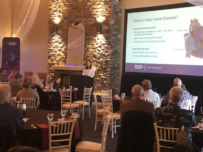 A photo of Dr. Jennifer Riggs speaking at a podium