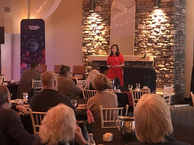 A photo of Dr. Nadira Hamid speaking at a podium