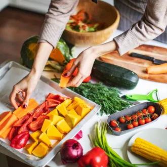 woman putting vegetables on tray