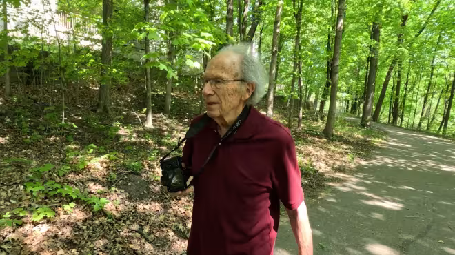Johnny walking in the woods with his camera