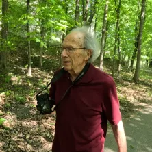 Johnny walking in the woods with his camera