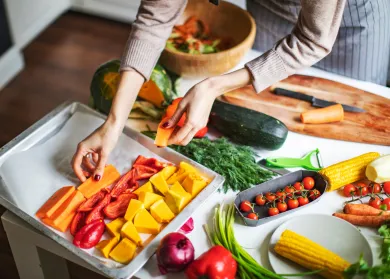 woman putting vegetables on tray