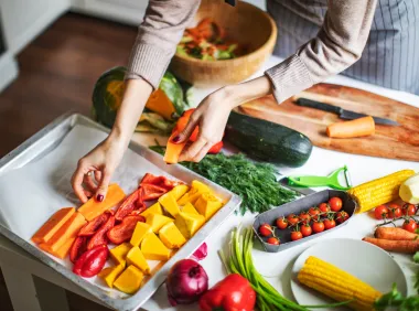 woman putting vegetables on tray